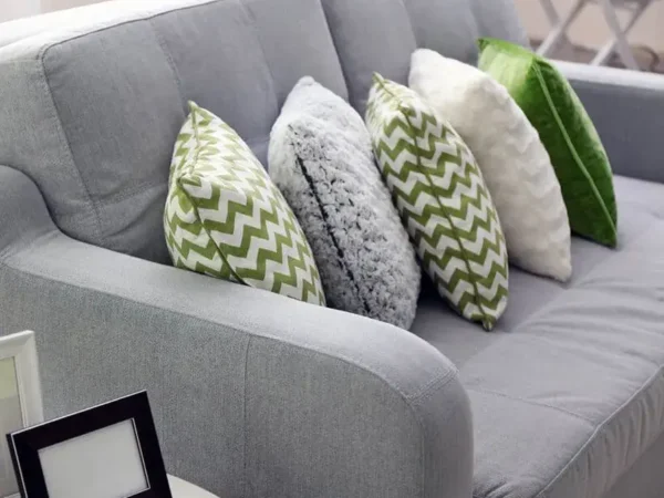 Gray sofa with green and white pillows