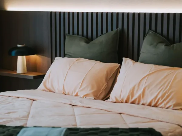 Cozy bed with soft pillows and blanket.