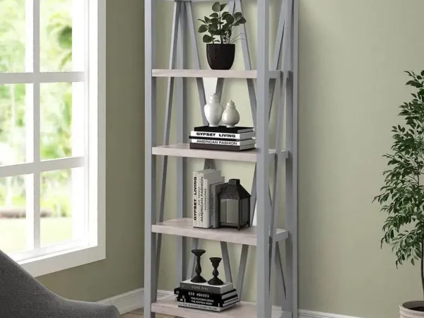 Modern gray bookshelf with decorative items by window.