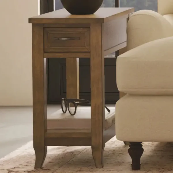 Wooden side table with drawer beside a sofa.