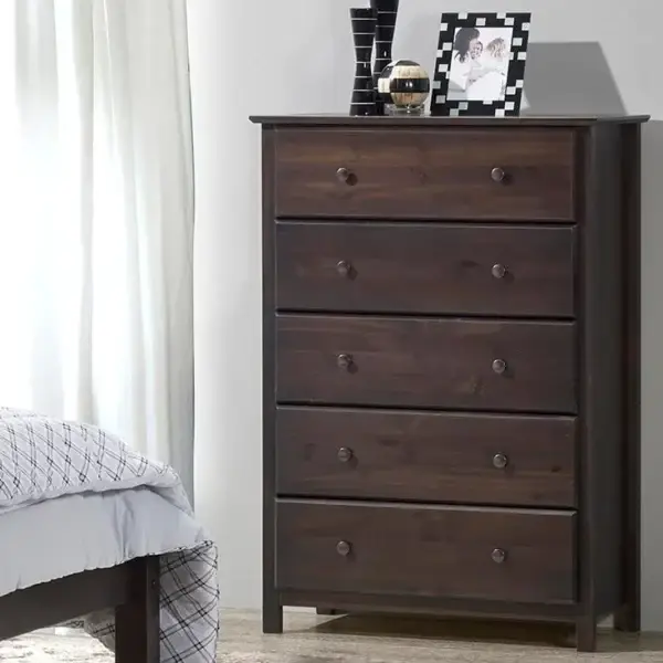 Dark wood dresser with five drawers in bedroom.