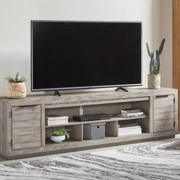 TV on rustic wood entertainment center with decor.