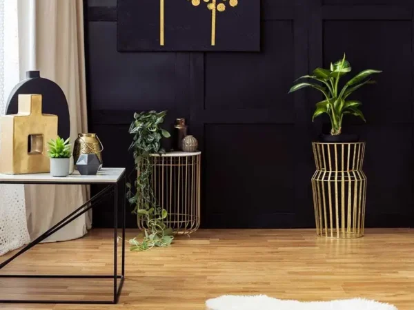 Modern living room with gold accents and plants.