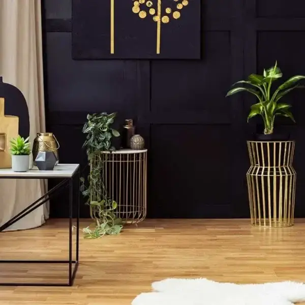 Modern living room with gold accents and plants.