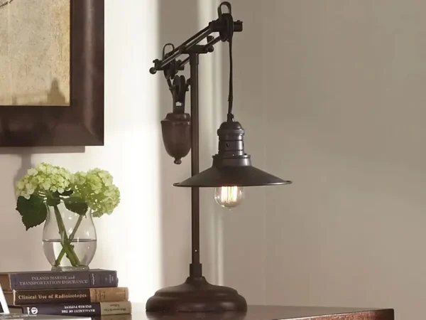 Vintage table lamp beside flowers and books.