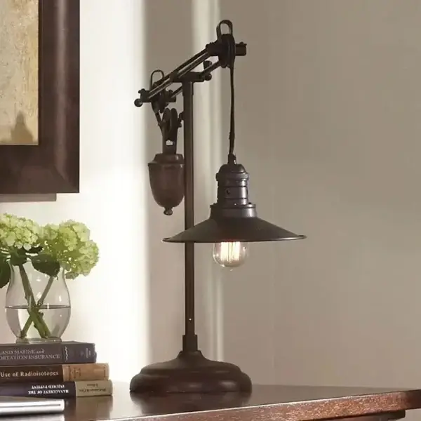 Vintage table lamp beside flowers and books.