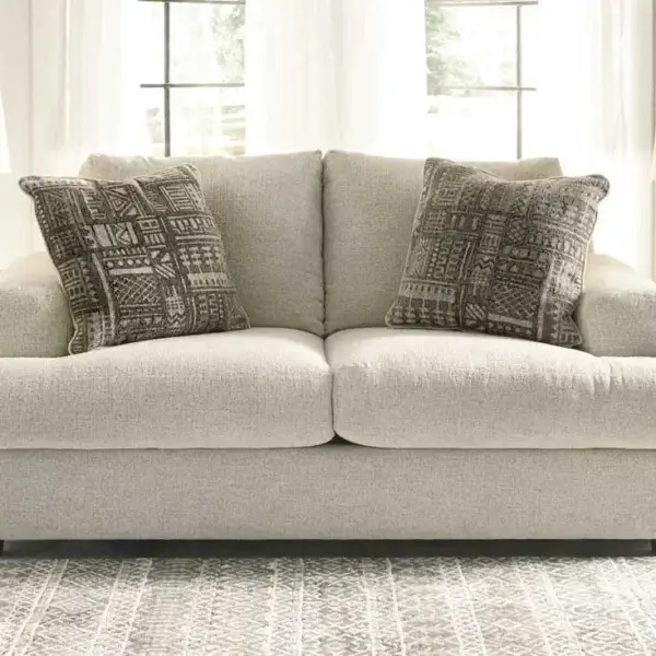 Cozy beige sofa with patterned cushions in living room.
