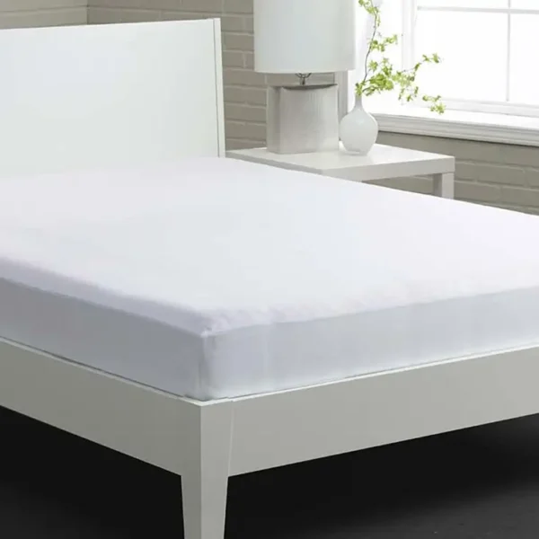 White bed with fitted sheet and nightstand.