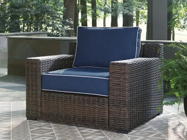 Wicker patio chair with blue cushions outdoors