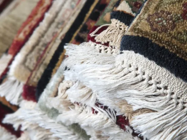 Textured colorful rugs with fringes close-up.