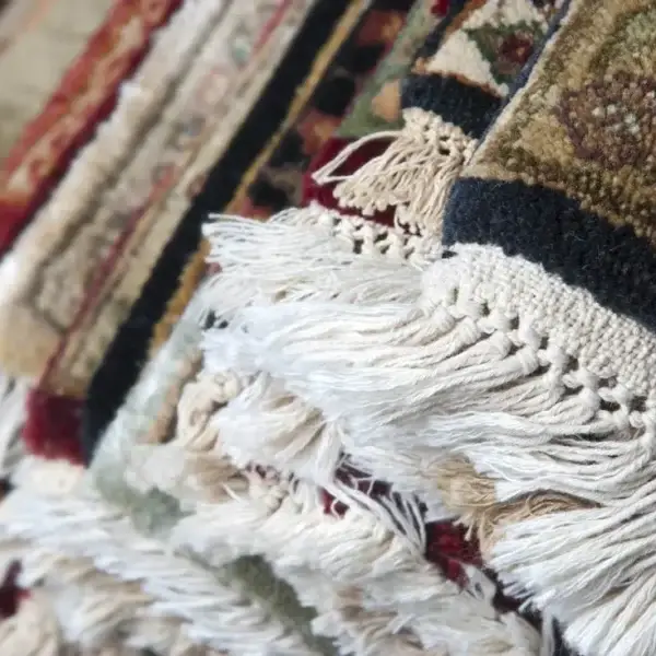 Textured colorful rugs with fringes close-up.
