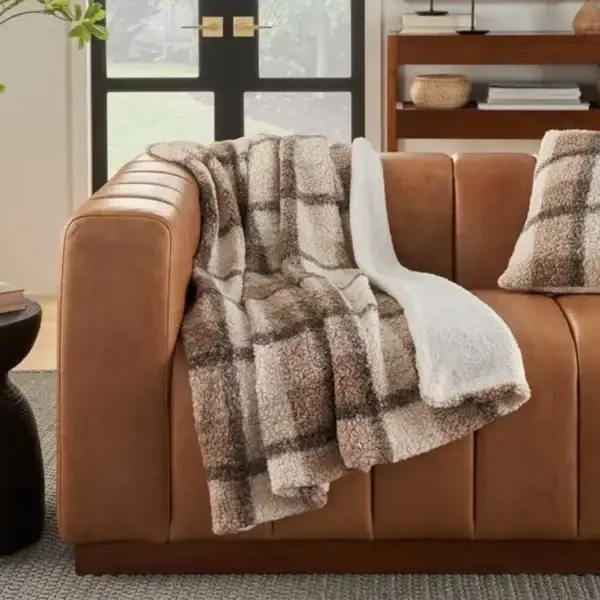 Cozy plaid throw on brown leather couch