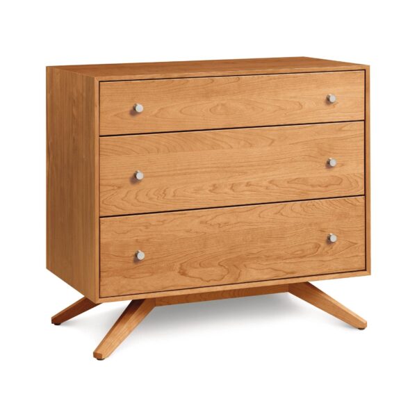 Three-drawer light wood dresser with mid-century modern legs.