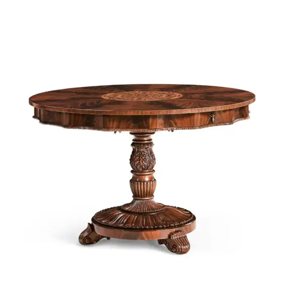 Ornate dark wood round pedestal table with intricate carvings.