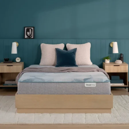 BeautySleep mattress on a wooden frame in a teal bedroom.