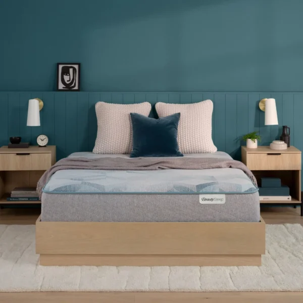 BeautySleep mattress on a wooden frame in a teal bedroom.