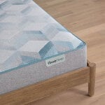 BeautySleep mattress with geometric blue pattern on wooden bed frame.