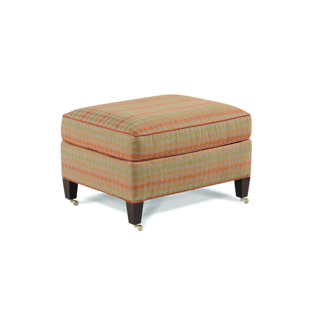 babington ottoman Patterned fabric ottoman with orange trim and caster wheels.