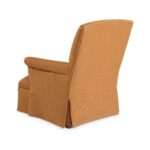Rear view of a mustard yellow upholstered armchair with skirt.