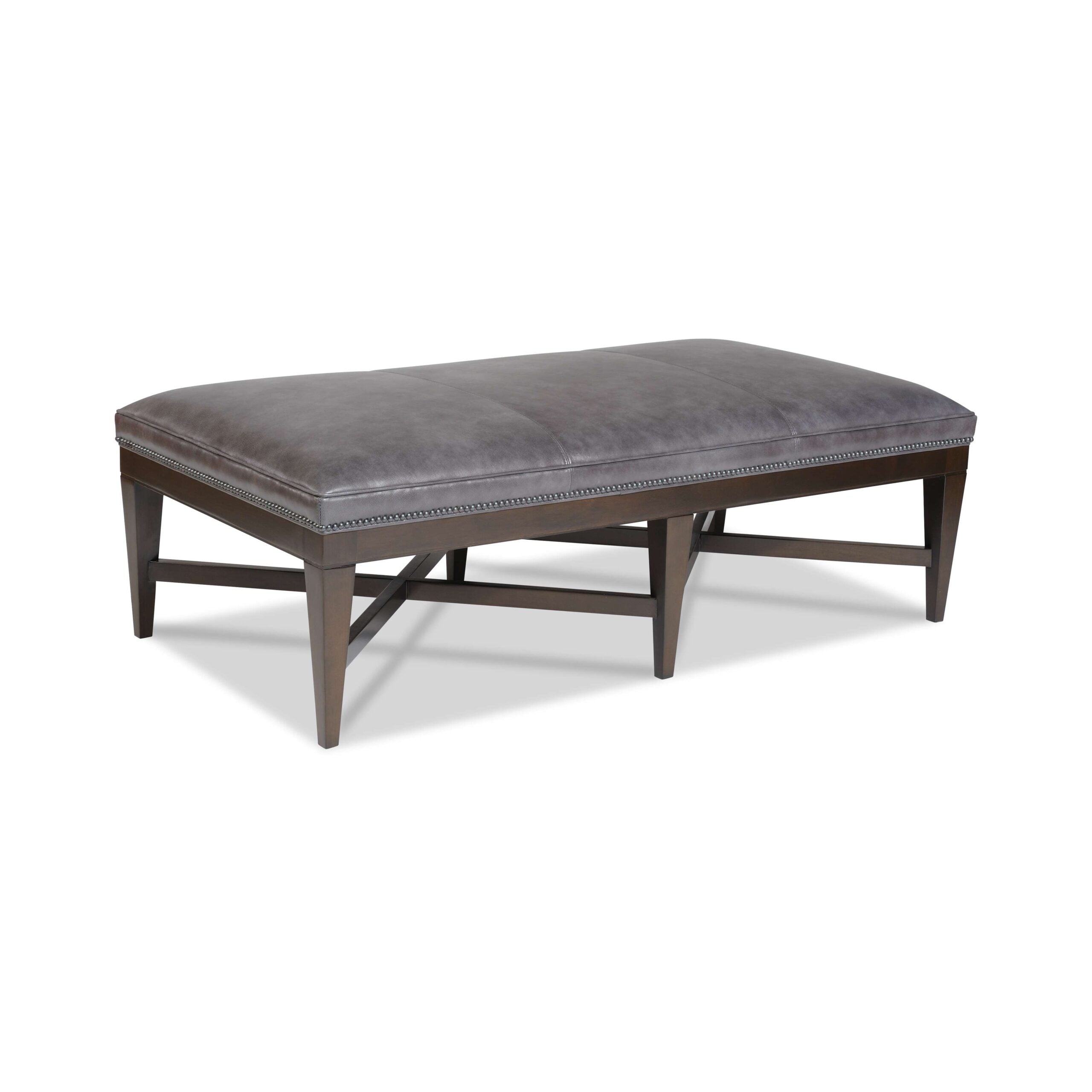 gordon leather bench Gray leather upholstered rectangular cocktail ottoman with dark wood base.