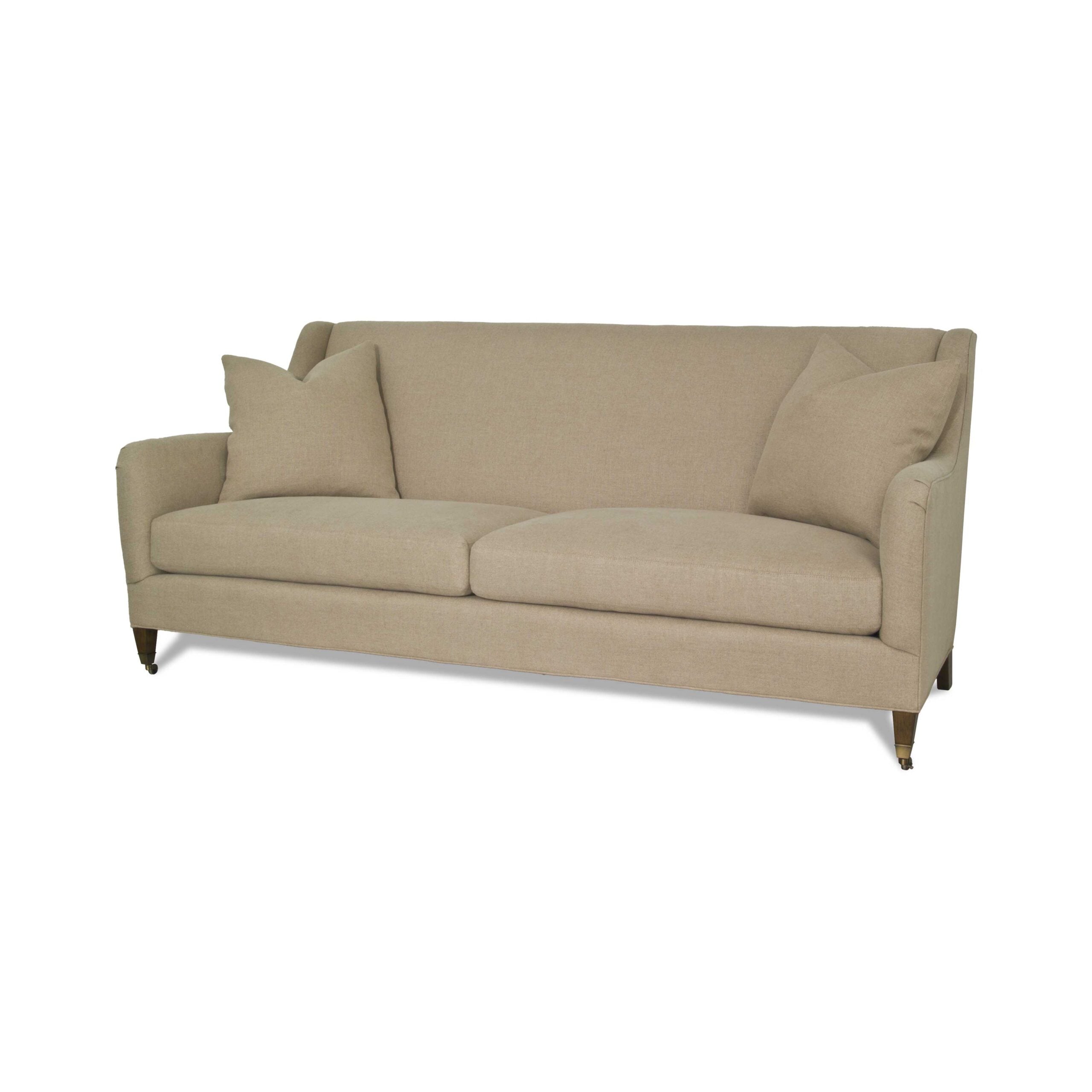 hughes sofa Beige fabric sofa with two throw pillows and wheel casters.