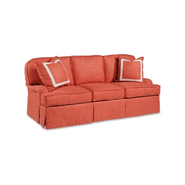 Coral three-seater sofa with accent pillows and skirted base.
