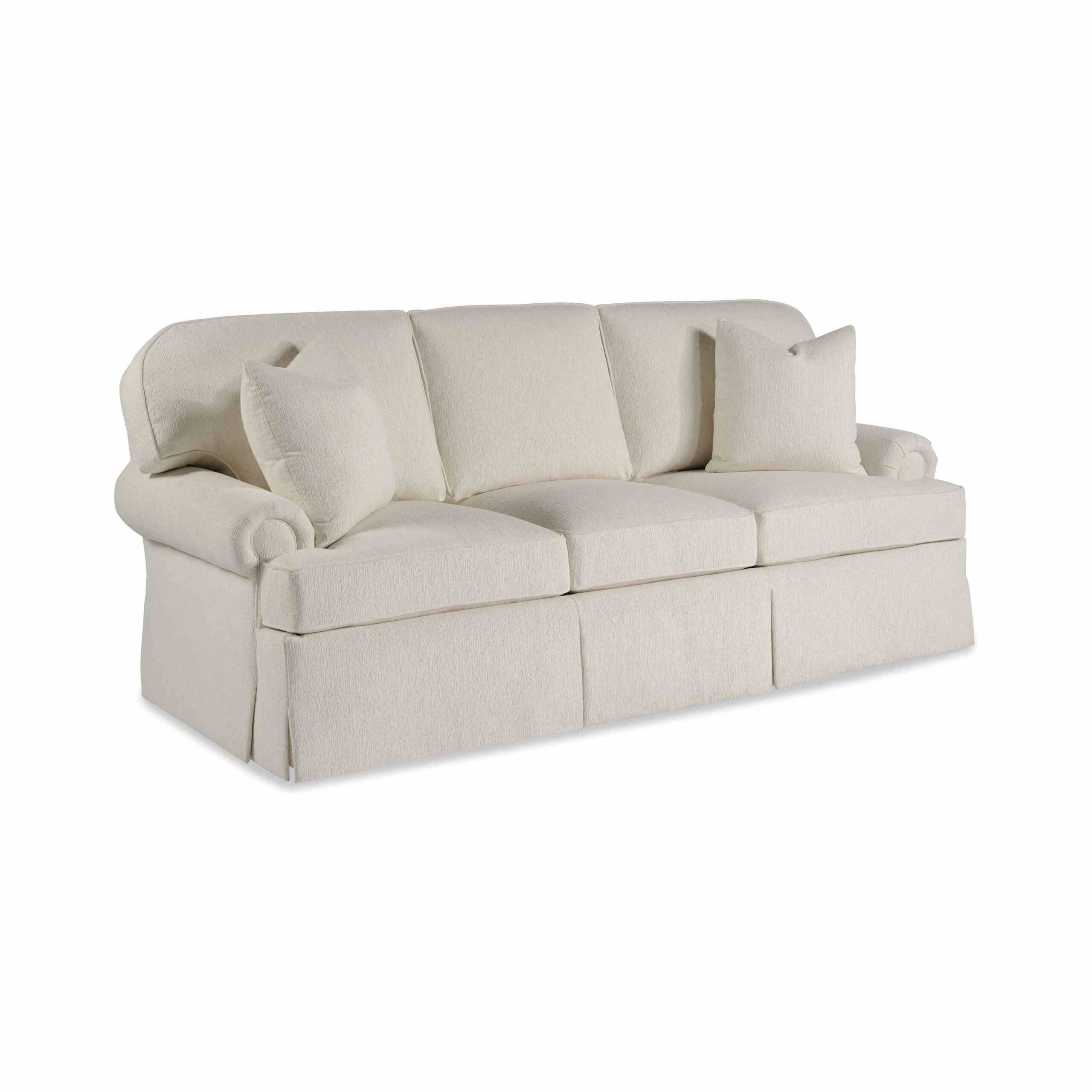 taylor made standard sofa Cream-colored three-seater skirted sofa with rolled arms and pillows.