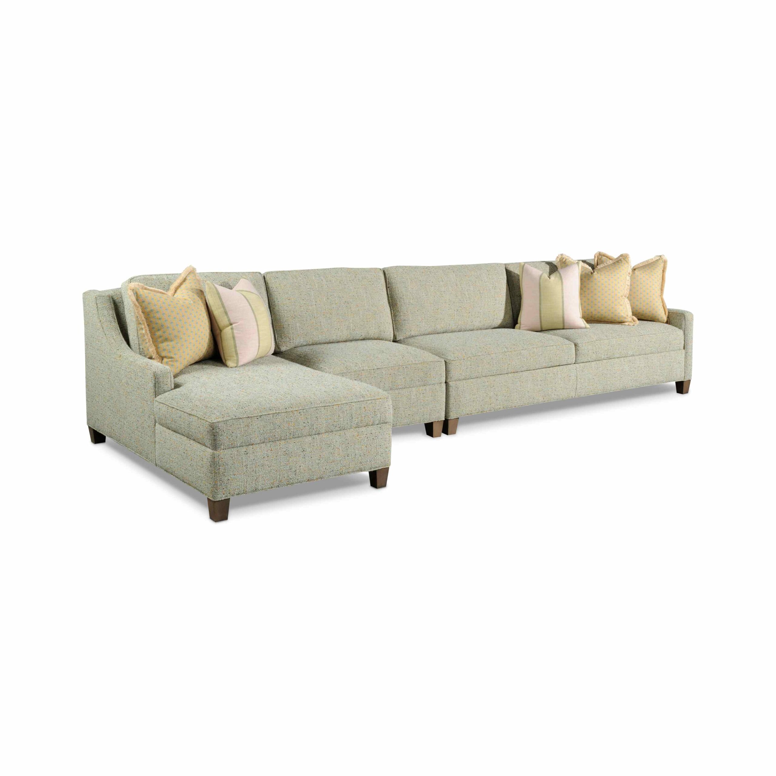 connor sleep sectional Large light green sectional sofa with colorful decorative pillows.