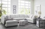 Large L-shaped light gray sectional in a sunlit living room.