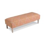 Coral floral damask upholstered bench with white turned legs.
