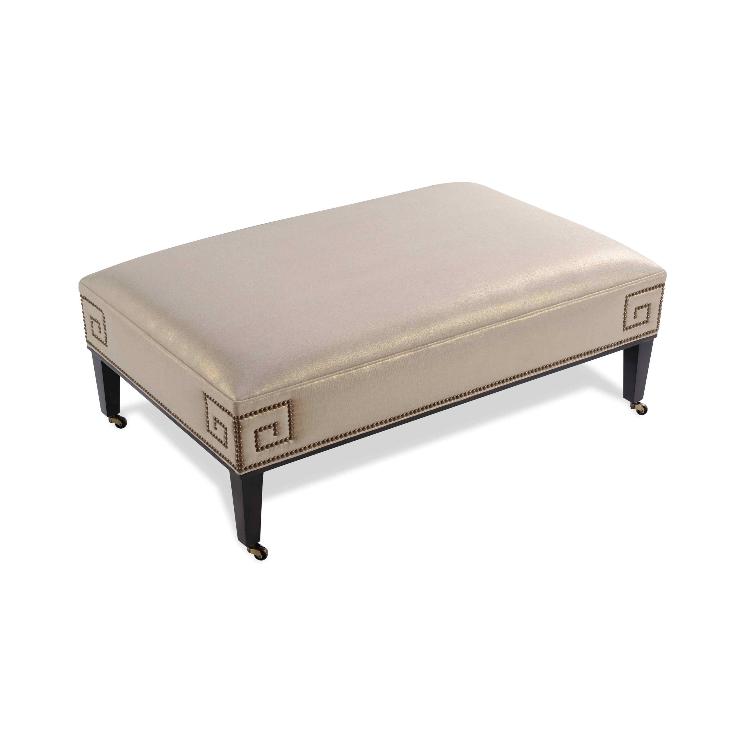 taylor made rectangular ottoman Champagne upholstered ottoman with Greek key nailhead trim and casters.