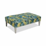 Rectangular ottoman with blue and yellow patterned fabric and wooden legs.